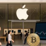 Ingang van een Apple Store met het Apple-logo boven de glazen pui bij daglicht