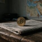 Fysieke bitcoin-munt op een opgevouwen krant met een kaart van het Midden-Oosten op de achtergrond