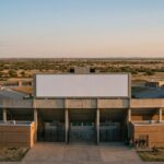 Amerikaans universiteitsstadion in het vlakke landschap van West-Texas bij schemering