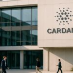 Modern kantoorgebouw met het Cardano-logo op de gevel bij helder daglicht