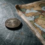 Symbolische stablecoin-munt op een stalen ondergrond naast een wereldkaart met het Midden-Oosten, wat de bevriezing van tegoeden verbeeldt
