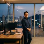 Analist in een rustig, modern handelskantoor in Seoul bij schemering, kijkend richting de camera
