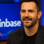 Coinbase-CEO Brian Armstrong tijdens een televisie-interview met het Coinbase-logo op de achtergrond
