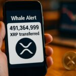 Smartphone toont een melding van een grote XRP-transactie met het XRP-logo op het scherm