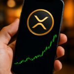 Smartphone toont het XRP-logo met een groen stijgende koersgrafiek op een beurs-app